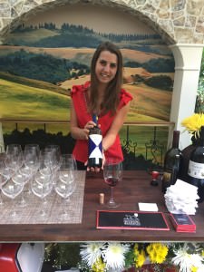 Sommelier Margaux shows off the Gaja Ca'Marcanda Promis 2013 she is pouring at the Italy pavilion